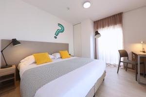 Un dormitorio con una gran cama blanca con almohadas amarillas. en Apparteo Bordeaux, en Burdeos