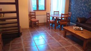a living room with a couch and a table and chairs at Duplex Calle El Tillo in Escarrilla