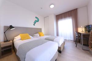 Una habitación de hotel con dos camas y una ventana. en Apparteo Bordeaux, en Burdeos
