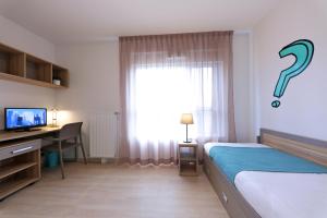 Un dormitorio con una cama y un escritorio y una ventana. en Apparteo Bordeaux, en Burdeos
