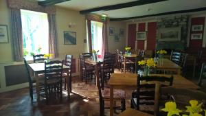 comedor con mesas y sillas de madera en The Old Dungeon Ghyll Hotel en Great Langdale