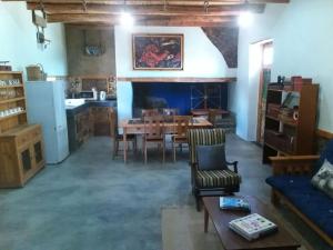 a living room with a table and a kitchen at Silwerkaroo Gastehuis in Klaarstroom