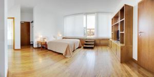 a bedroom with a bed and a desk and a window at Hotel Rubin in Düsseldorf