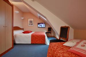 En eller flere senge i et værelse på Logis Hotel des Lacs