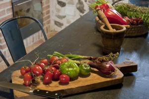 a cutting board with tomatoes and other vegetables on a table at Residenza d'Epoca Borgodifiume in Fiumefreddo Bruzio