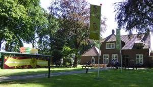 una casa con le bandiere e un cartello davanti di Stichting Veenloopcentrum Weiteveen a Weiteveen