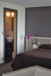 1 dormitorio con cama, lavabo y baño en Hôtel de la Baie des Trépassés en Plogoff
