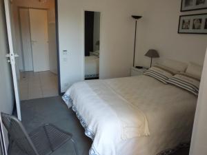 フレジュスにあるLE CESAREE 3Jのベッドルーム(大きな白いベッド1台、椅子付)