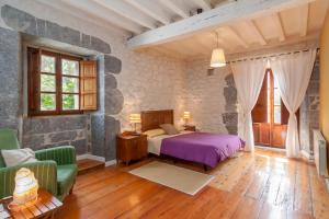 a bedroom with a bed and a couch and a window at Casona Valle de Soba in Regules