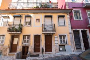 リスボンにあるSanto António Apartmentの窓とドアがたくさんある古い建物