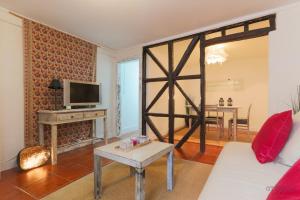a living room with a white couch and a tv at Santo António Apartment in Lisbon