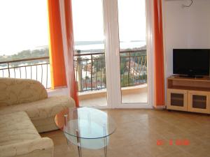 a living room with a couch and a glass table at Panoramic Penthouse Sozopol in Sozopol