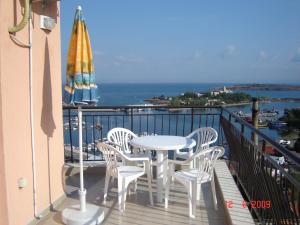 a balcony with a table and chairs and an umbrella at Panoramic Penthouse Sozopol in Sozopol