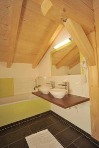 uma casa de banho com 2 lavatórios e uma banheira em Appartement Sonnengarten em Ramsau am Dachstein
