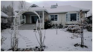 una casa con un patio cubierto de nieve delante en Habitat, en Clarens