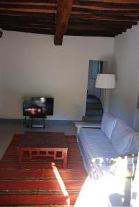 a living room with a couch and a tv at Garden Apartment in Greve in Chianti
