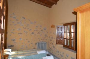 ein Schlafzimmer mit einer gelben Wand mit einem Bett und einem Fenster in der Unterkunft Casa Rural La Vallejera in Tejeda de Tiétar