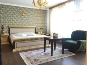 a bedroom with a bed and a table and a chair at Hotel Adria in Prishtinë