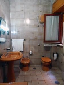 bagno con lavandino, servizi igienici e specchio di Casa Relax Mare Trebisacce a Trebisacce