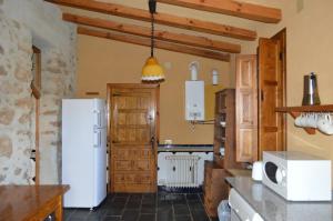 a kitchen with a white refrigerator in a room at Casa Rural La Vallejera in Tejeda de Tiétar