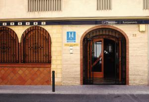 uma entrada para um edifício com uma porta aberta em Hostal la Campana em Motril