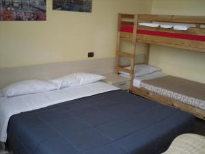 um quarto com 2 beliches e uma cadeira em Hostel San Marino em San Marino