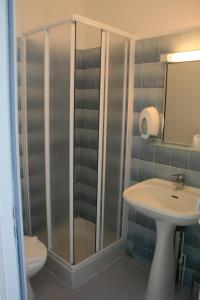 een badkamer met een douche, een wastafel en een toilet bij Logis Hôtel Le Jabron in La Bégude-de-Mazenc