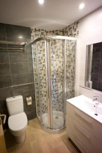 y baño con ducha, aseo y lavamanos. en Apartamento Premium Playa Altar 2, en Barreiros