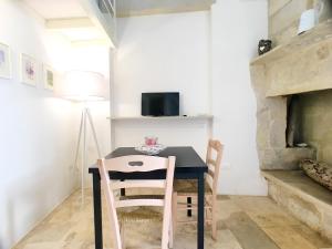 a table and chairs in a room with a fireplace at Dimore Nonna Ina in Maglie