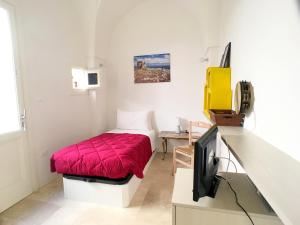 a small room with a bed and a television at Dimore Nonna Ina in Maglie