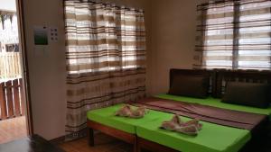 una camera con un letto verde e una finestra di Rubin Resort a San Vicente