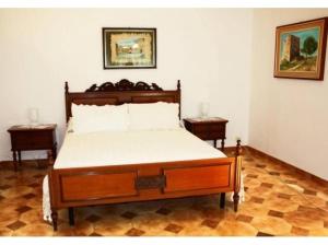 シラクーサにあるVilla Danteのベッドルーム1室(木製ベッド1台、ナイトスタンド2台付)