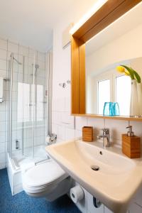 a bathroom with a sink and a toilet and a shower at Hotel am Peterstor in Regensburg
