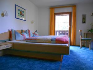 1 dormitorio con cama, mesa y ventana en Haus Thurner, en Obsteig