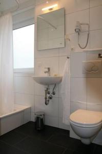 y baño con aseo y lavamanos. en Apartment-Haus, en Colonia