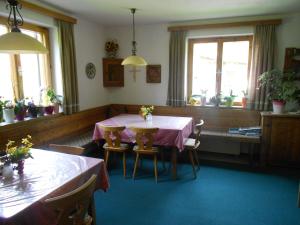 a dining room with a table and chairs and windows at Haus Thurner in Obsteig