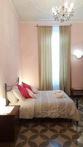 sypialnia z łóżkiem z czerwonymi poduszkami i żyrandolem w obiekcie Royal Suite w Genui