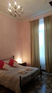 sypialnia z łóżkiem z żyrandolem i oknem w obiekcie Royal Suite w Genui