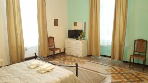 a bedroom with a bed and a tv and two chairs at Royal Suite in Genoa