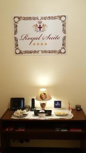 znak na ścianie nad stołem z lampką w obiekcie Royal Suite w Genui