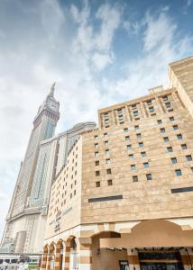 un grand bâtiment avec une tour d'horloge en arrière-plan dans l'établissement Makarem Ajyad Makkah Hotel, à La Mecque