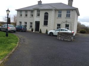 ein Haus mit zwei Autos, die in einer Einfahrt geparkt sind in der Unterkunft Keyfield House in Mullingar