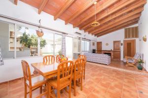 a dining room with a wooden table and chairs at Ca Na Dora in Santanyi