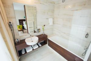 a bathroom with a sink and a tub and a mirror at Hotel Zochova Chata - Adult friendly in Modra