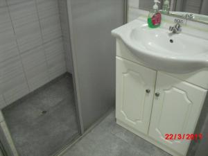 y baño blanco con lavabo y ducha. en Kelebek Hostel, en Lima