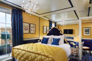 Un dormitorio con una cama con paredes amarillas y una lámpara de araña. en Rubens At The Palace, en Londres