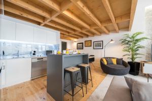 an open kitchen and living room with white cabinets at LovelyStay-Modern Loft City Center in Porto