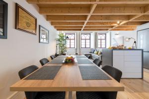 a dining room with a large wooden table and chairs at LovelyStay-Modern Loft City Center in Porto