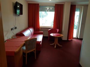 ヘッペンハイム・アン・デア・ベルクシュトラーセにあるWaldschenke Fuhrのソファ、テーブル、窓が備わる客室です。