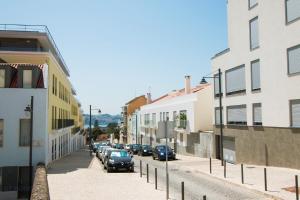 uma rua da cidade com carros estacionados na rua entre edifícios em Pateo da Paz em Lisboa